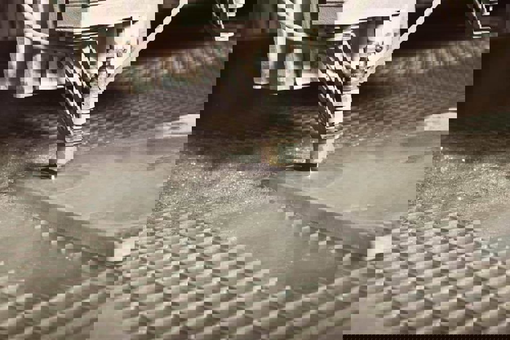 Närbild av en vattenstråleskärare som bearbetar en metallplåt.