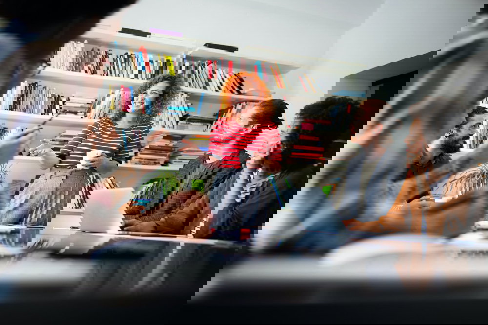 Mötesdeltagare lyssnar uppmärksamt på en kvinna som håller en presentation.