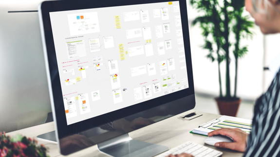 En kreativ arbetsmiljö med en dator som visar en översikt av projekt och idéer.