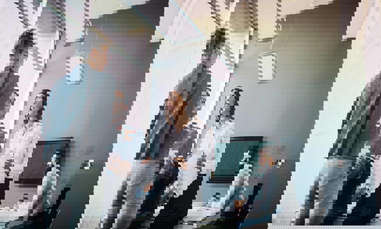 Professionella kollegor samarbetar i ett stilrent kontor, med fokus på kommunikation och teamwork.