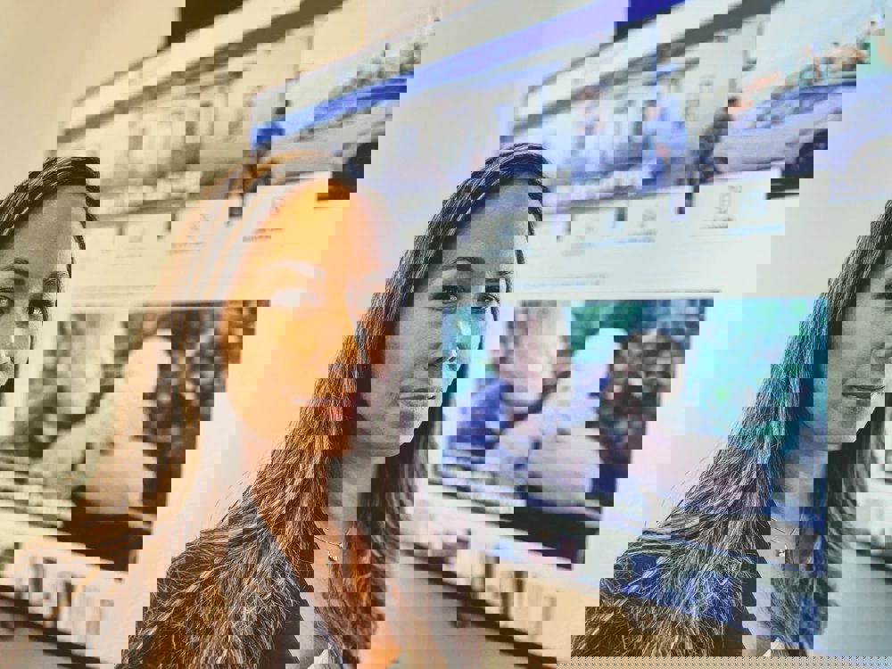 Professionell kvinna poserar framför en digital skärm med kundcase.