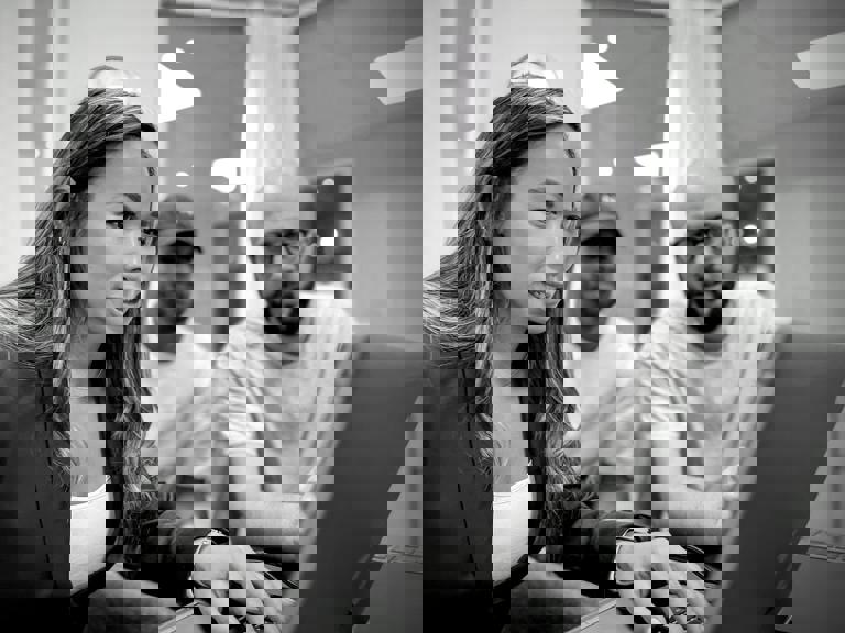 Tre personer samarbetar vid en dator i ett kontorsutrymme, fokuserade på skärmen.