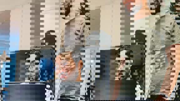 Två personer samarbetar vid en dator på kontoret.